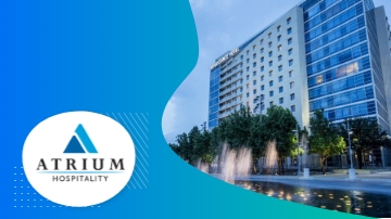 Atrium Hotel with modern architecture, lush landscaping, and a serene water feature for hospitality.