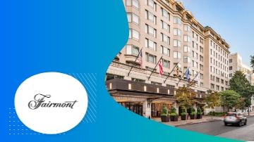 Fairmont DC hotel, a large building with a car parked on the street, and a blue sky.