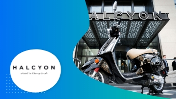 A black scooter parked in front of a building with the word Halcyon on it.