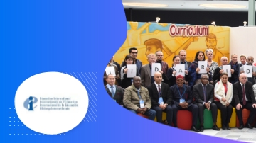 A group of people holding letters spelling out 'DARE' in front of a yellow poster reading 'Curriculum'.