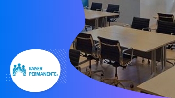 A classroom with desks and chairs and a Kaiser Permanente logo in the corner.