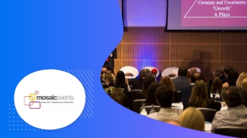 A group of people sitting in chairs in front of a projector screen.