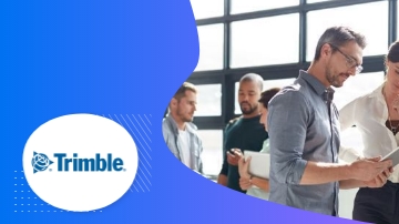 A group of people standing in front of a glass window, with the text "Trimble" on the left.