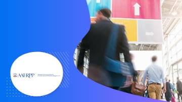 A group of people in a hallway with a sign and a logo of AAHRPP.