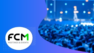 A crowd of people in a conference hall with the FCM logo in front of the image.