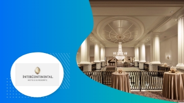 The grand lobby of the Barclay Hotel, with a chandelier, tables, and columns.