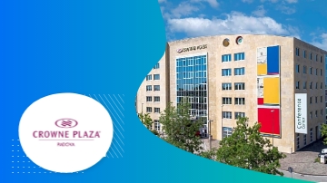 Crowne Plaza Padova hotel building with modern architecture, greenery, and blue sky background.