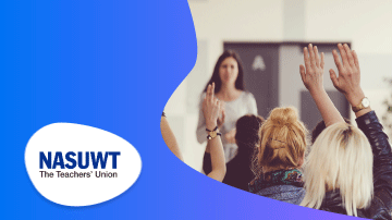 A woman is standing and raising her hand in front of a group of people in the room.