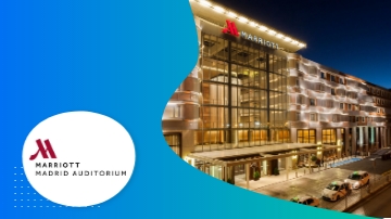 Madrid Marriott Auditorium Hotel and Conference Center, a modern building with glass windows and a blue sky.