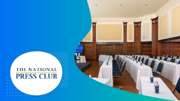 The National Press Club interior view with tables, chairs, and text on a blue background.