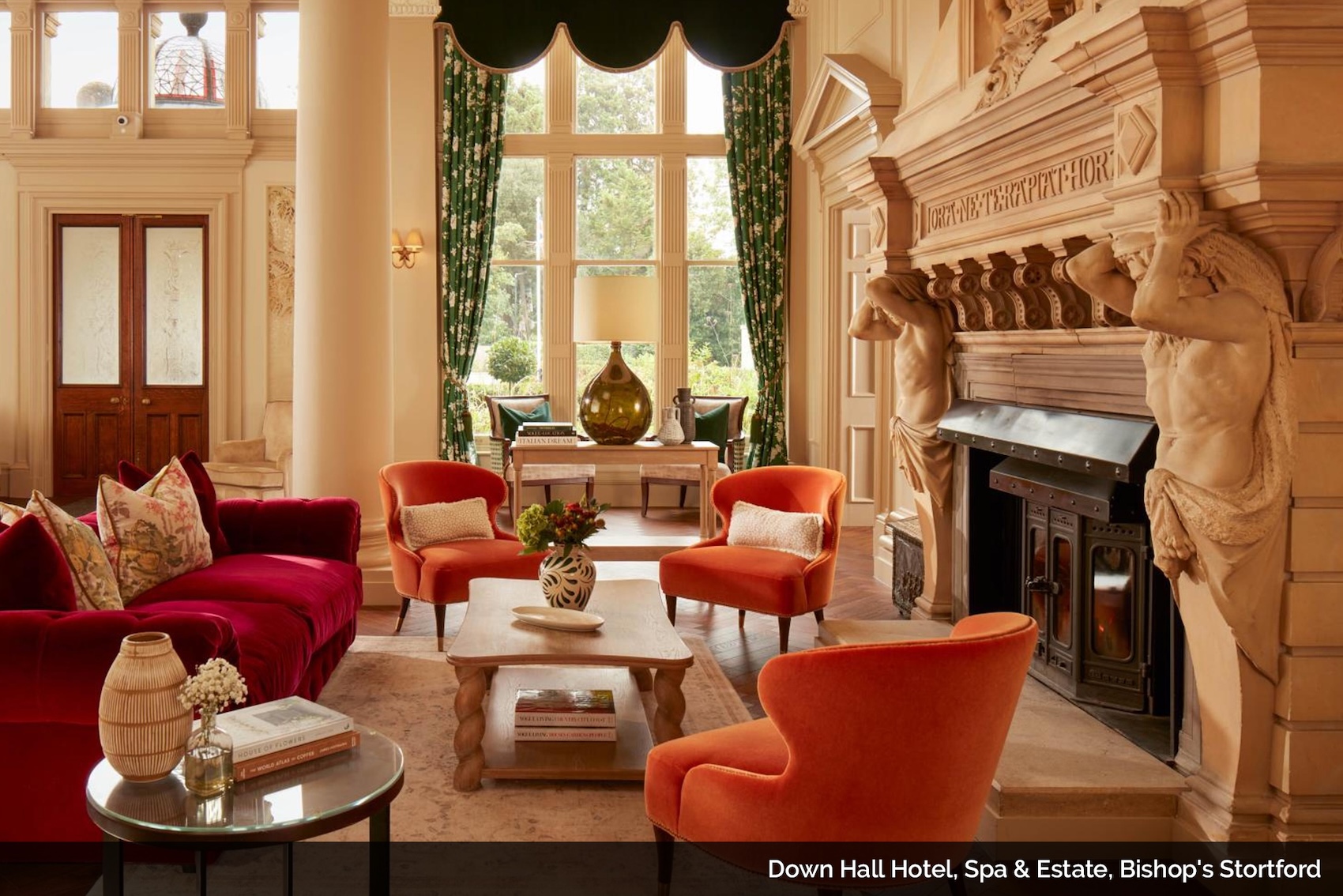 Luxury sitting room with large fireplace and red accent chairs