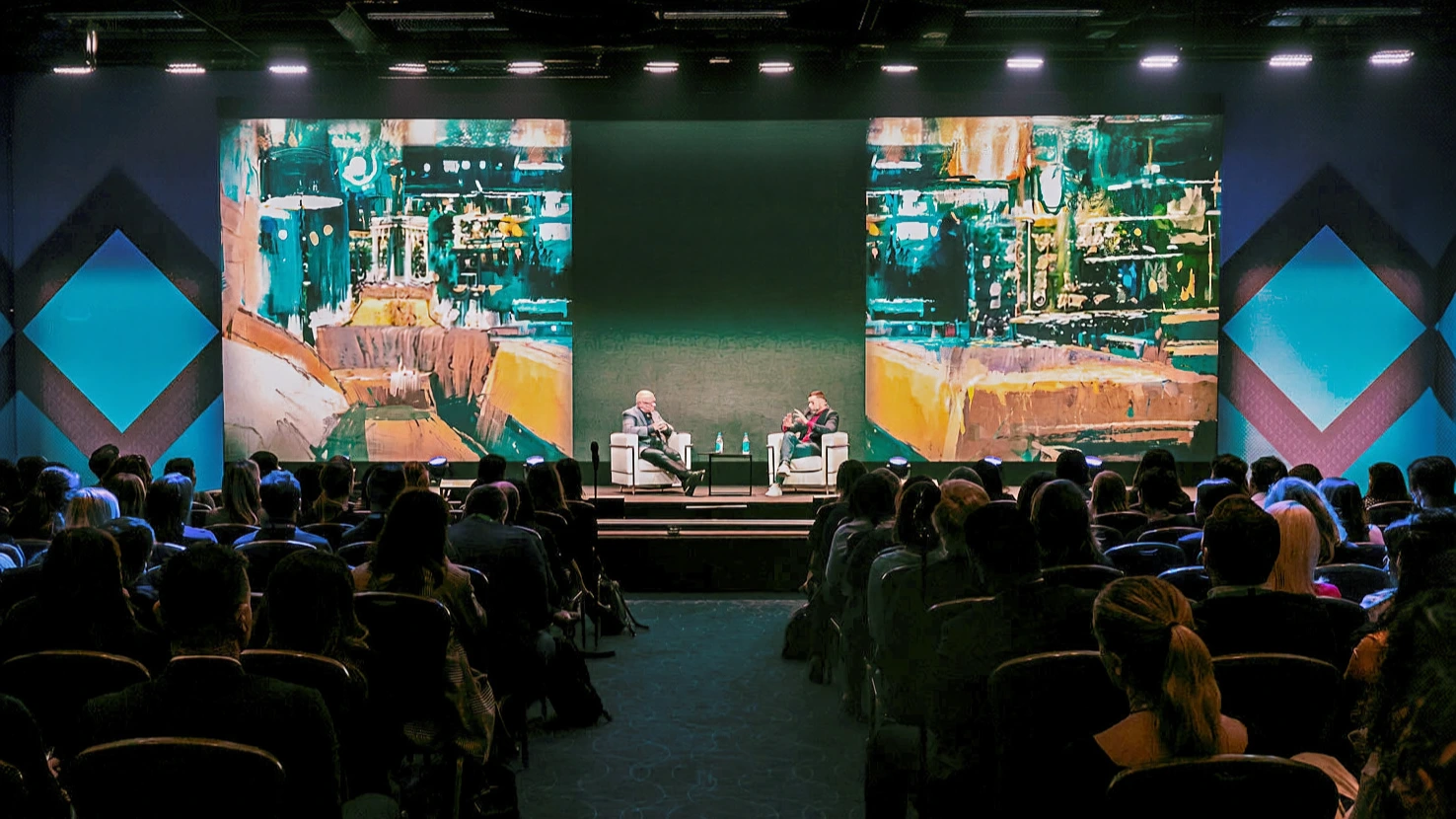 Two speaker on stage at a dark event nenue