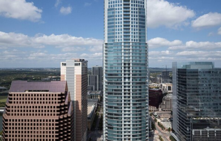 View of the skyline in Austin from the top of the Austonian building with blue sky background.