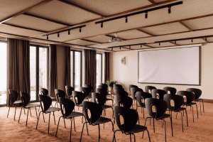 An empty meeting room with chairs and a large screen on the wall in Hotel Nacional.