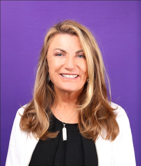 Picture of contributor Annette Gregg Headshot of white female against a purple background 
