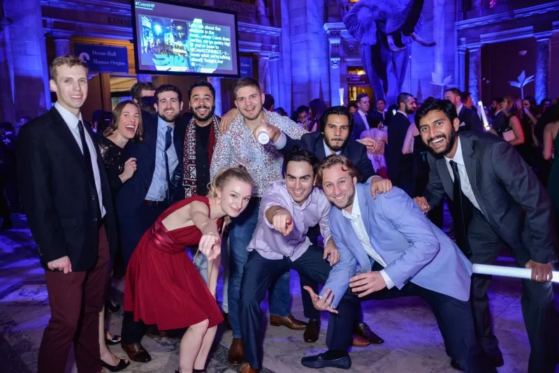 Group of people at a social event with elephant statue in the background.