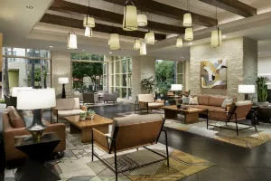 Lobby of The Marq with couches, chairs, and lamps on a carpet.