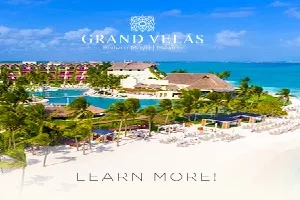 Aerial view of Grand Velas resort, with beach, pool, and architecture, promoting "Learn More!"