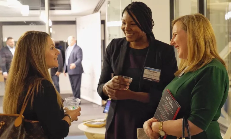 Three women chat at a Federal Reserve Bank of Atlanta event in Atlanta, Georgia, in November 2023.