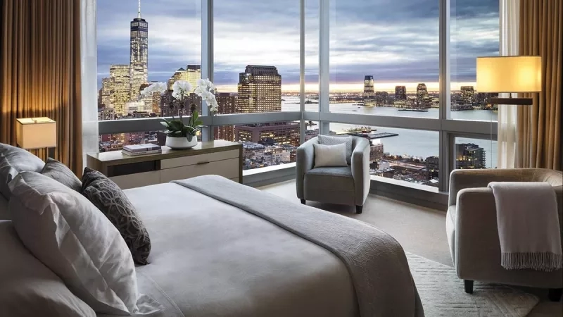 Bedroom at The Ritz-Carlton, New York, NoMad with a view of the city at dusk