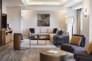 A cozy living room with a sofa, a coffee table, and a TV on a cabinet.