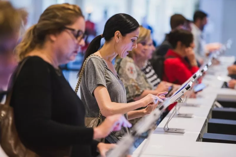 Group of women looking at screens at a conference with on-demand badge printing.