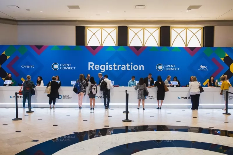 Event Connect registration table with people standing in line and staff behind the counter.