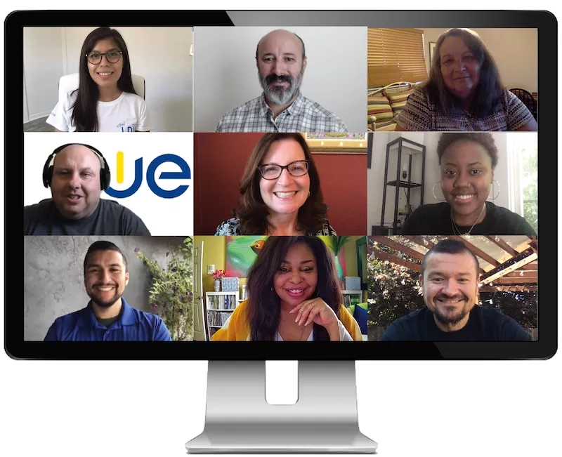 A desktop with a screen that shows the current CUE team on a Zoom call.