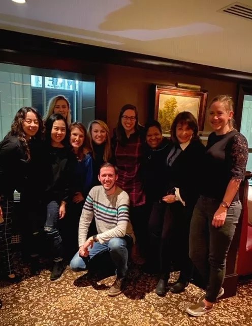 Group photo of nine women and one man inside the Four Seasons Hotel in NYC.