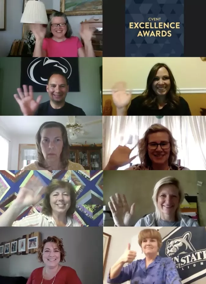 A photo of 10 people with their hands up and smiling in front of Penn State logos.