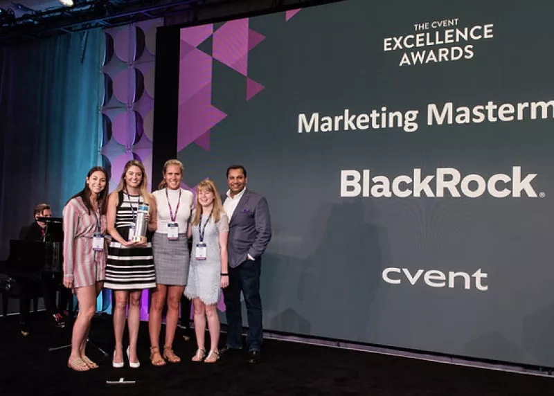 Five people posing for a photo in front of a screen that reads "The Cvent Excellence Awards."