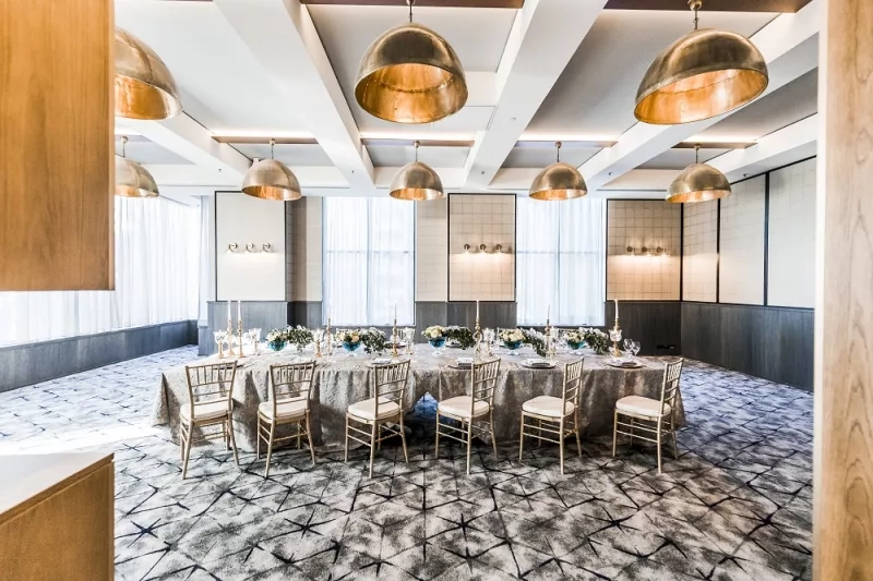 The Hart Room is set up for a wedding reception with round tables, chairs, and decorative elements.