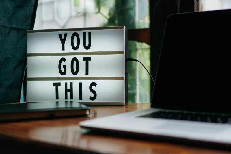 Laptop, notebook, and light box with "You Got This" written on it, creating a motivational atmosphere.