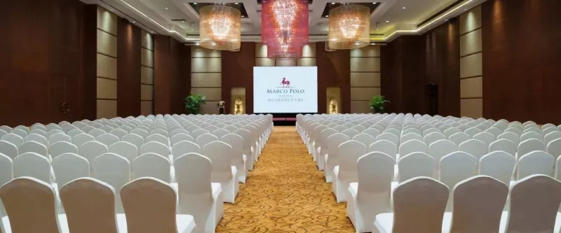 Ballroom of Marco Polo Shenzhen with rows of chairs and a white screen at the end.