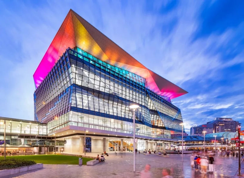 The ICC building with vibrant rooftop lighting, modern architecture, and surrounding landscaping at dusk.
