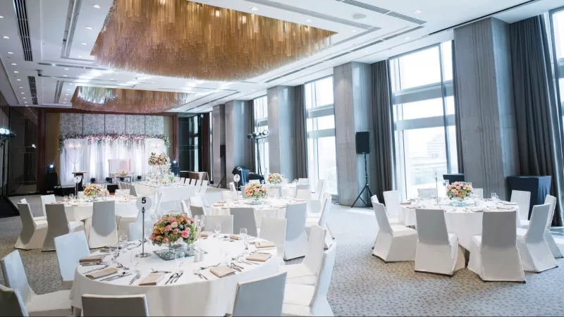Banquet hall at Marco Polo Manila with white chairs and tables, floral centerpieces, and a modern design.