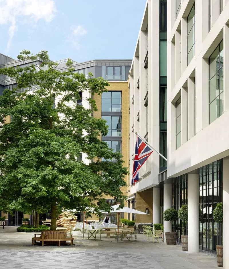 Picture of the exterior of the building with a British flag hanging in front of the tree