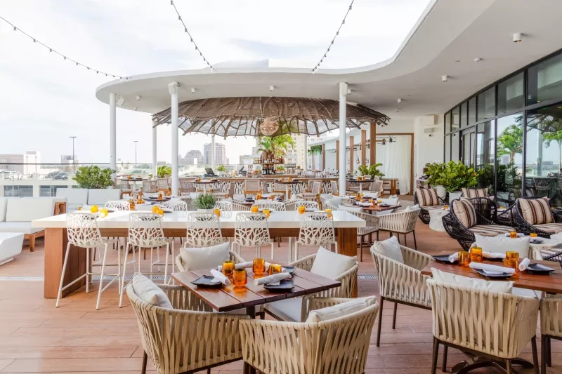 Spruzzo Rooftop at The Ben West Palm Beach restaurant with tables and chairs set up for small meetings.