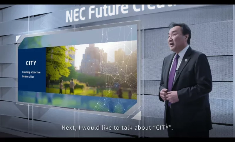 A man standing in front of a screen with a picture of CITY and text next to it.