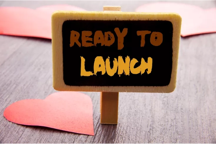 Ready to Launch sign with hearts on a wooden surface.