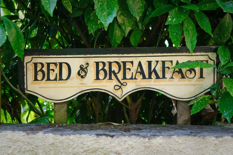 Sign for a bed and breakfast hotel that is set in lush greenery and a beautiful ambiance.