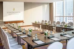 Meeting room with desks and chairs, and a screen with "Intercontinental" written on it.