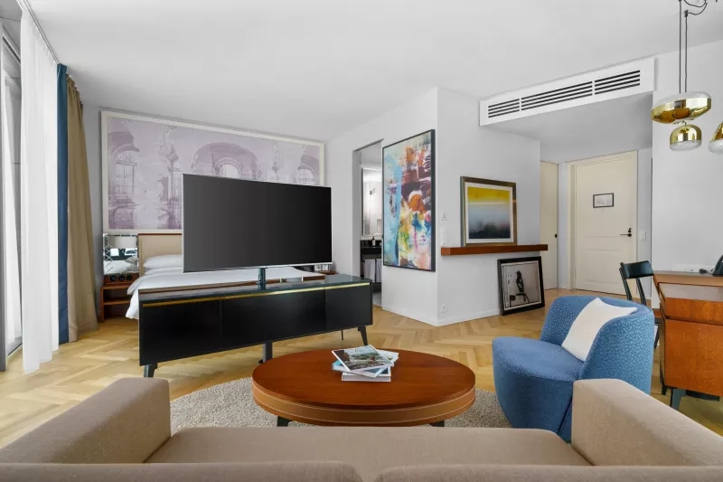 The Andaz Tel Aviv Hotel living room with a couch, TV, and coffee table with books.