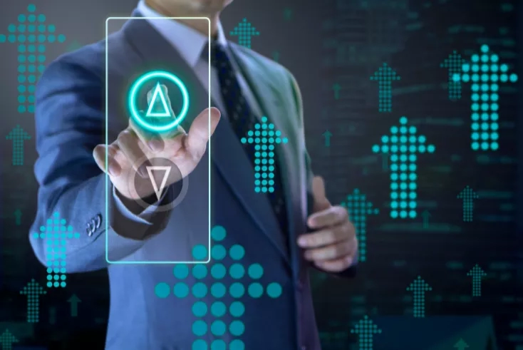 Businessman in suit using his finger to touch a screen with a triangle and arrows in background.