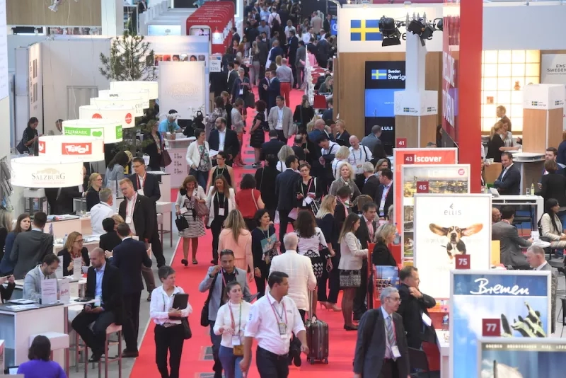 Frankfurt Show, showing the aisle with many people walking around and a variety of booths and advertisements.