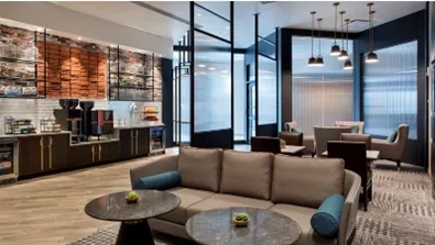 Lounge area of AC Hotel by Marriott New York Times Square with tables, couches, and modern design.