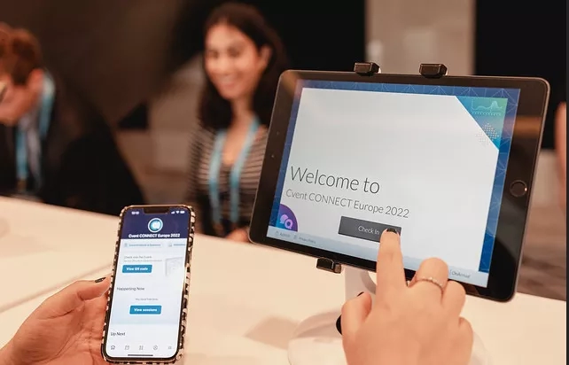 A woman checking in at a kiosk with a mobile app at Event Connect Europe 2022.