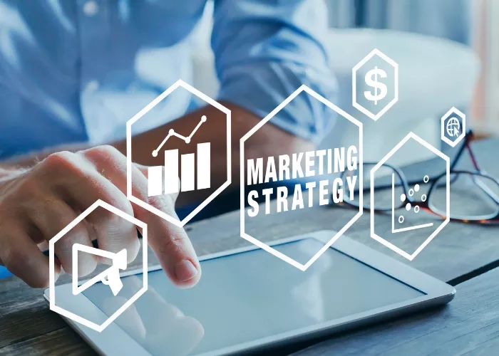 A man using a tablet with icons of a graph, dollar sign, globe, and megaphone around it.