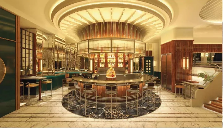 An interior view of the lobby bar with a circular bar and staircase at the Savoy London.
