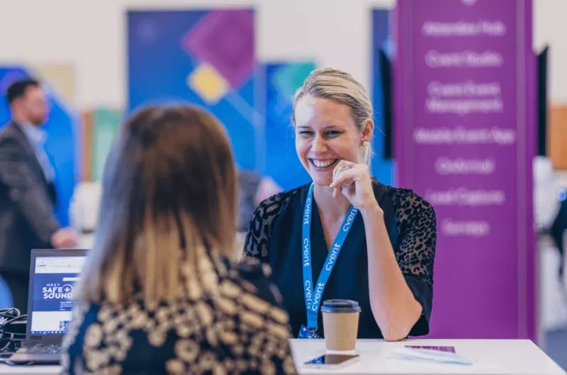 Two women are having a conversation with each other at a B2B event.